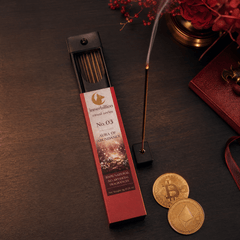 Incense stick with packaging on a dark surface with coins and flowers