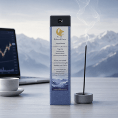 Incense stick with packaging on a desk with a laptop and coffee cup, mountain background