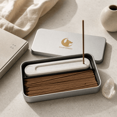 Incense sticks in a metal and white container with 'Inner Billion' logo on a light surface.