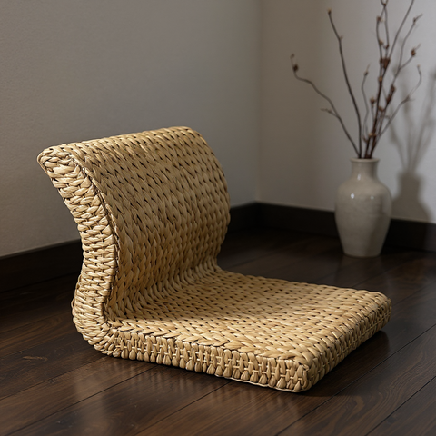 Woven floor chair on a wooden floor with a vase in the background