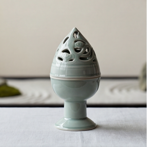 Light blue ceramic incense burner on a white surface with a neutral background
